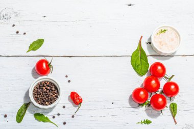 Modern culinary background with cherry tomatoes, spices and herbs. White wooden boards, trendy hard light, dark shadow, flat lay, top view