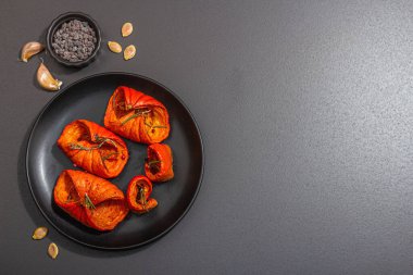 Baked pumpkin slices with honey, spices and seeds. Healthy vegan food, trendy hard light, dark shadow. Black stone concrete background, flat lay, top view