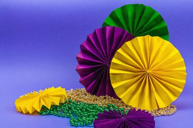 Festive Mardi Gras masquerade violet background. Fat Tuesday carnival, masks, beads, traditional decor. Symbolic colors, trendy hard light, dark shadow, flat lay, copy space