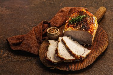Baharatlı fırında domuz filetosu ve eski ahşap kesme tahtasındaki baharatlar. Et dilimleri yemeye hazır, sağlıklı yaşam tarzı, akşam yemeği konsepti. Kahverengi taş arkaplan, düz döşeme, kopyalama alanı