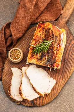 Baharatlı fırında domuz filetosu ve eski ahşap kesme tahtasındaki baharatlar. Et dilimleri yemeye hazır, sağlıklı yaşam tarzı, akşam yemeği konsepti. Kahverengi taş zemin, düz yatış, üst manzara