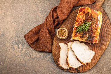 Baharatlı fırında domuz filetosu ve eski ahşap kesme tahtasındaki baharatlar. Et dilimleri yemeye hazır, sağlıklı yaşam tarzı, akşam yemeği konsepti. Kahverengi taş zemin, düz yatış, üst manzara