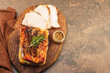 Baharatlı fırında domuz filetosu ve eski ahşap kesme tahtasındaki baharatlar. Et dilimleri yemeye hazır, sağlıklı yaşam tarzı, akşam yemeği konsepti. Kahverengi taş zemin, düz yatış, üst manzara