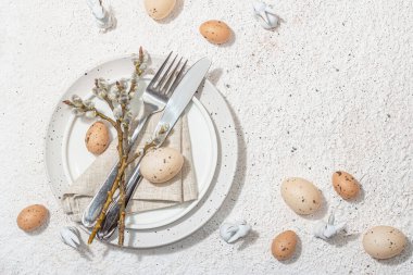 Yumurtalı, tavşanlı ve söğütlü Paskalya sofrası. Geleneksel bayram sembolleri, tebrik kartları, düz yatış. Modaya uygun sert ışık, koyu gölge, alçı arka plan, üst görünüm