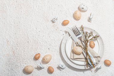 Yumurtalı, tavşanlı ve söğütlü Paskalya sofrası. Geleneksel bayram sembolleri, tebrik kartları, düz yatış. Modaya uygun sert ışık, koyu gölge, alçı arka plan, üst görünüm
