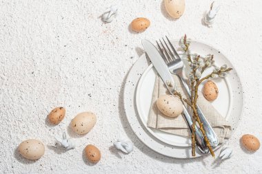 Yumurtalı, tavşanlı ve söğütlü Paskalya sofrası. Geleneksel bayram sembolleri, tebrik kartları, düz yatış. Modaya uygun sert ışık, koyu gölge, alçı arka plan, üst görünüm