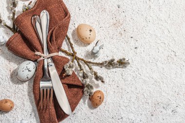 Yumurtalı, tavşanlı ve söğütlü Paskalya sofrası. Geleneksel bayram sembolleri, tebrik kartları, düz yatış. Modaya uygun sert ışık, koyu gölge, alçı arka plan, üst görünüm