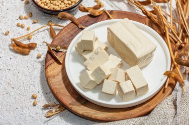 Soya fasulyeli taze tofu peyniri. Küp parçaları, vejetaryen yaşam tarzı için sağlıklı malzeme, modern duruş, modaya uygun sert ışık, karanlık gölge. Alçı arkaplan, düz yatak, yakın plan