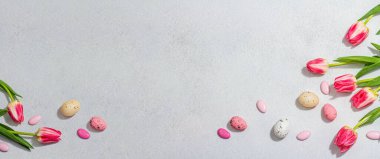 Paskalya yumurtalı pembe laleler. Kutlama konsepti, tebrik kartı, düz konum, sert ışık, koyu gölge, pankart biçimi