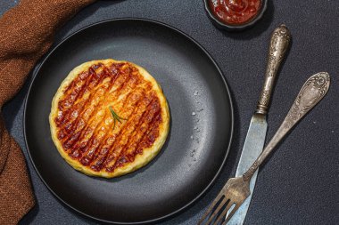 Tabakta ızgara Halloumi peyniri. Çatal bıçak takımı, piknik ya da barbekü için geleneksel yemek. Modaya uygun sert ışık, koyu gölge, düz zemin, siyah taş beton zemin, üst manzara