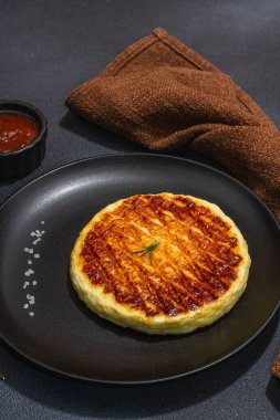 Tabakta ızgara Halloumi peyniri. Çatal bıçak takımı, piknik ya da barbekü için geleneksel yemek. Modaya uygun sert ışık, koyu gölge, düz zemin, siyah taş beton zemin, kapat