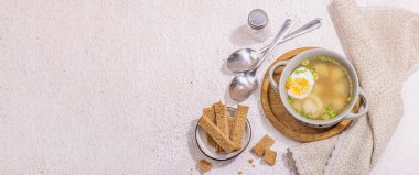 Haşlanmış yumurtalı köfte çorbası, ditalini makarna, sebze ve taze otlar. Sağlıklı tavuk çorbası, akşam yemeği için geleneksel sıcak yemek. Sert ışık, koyu gölge, taş beton zemin, afiş biçimi