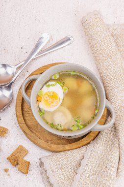 Haşlanmış yumurtalı köfte çorbası, ditalini makarna, sebze ve taze otlar. Sağlıklı tavuk çorbası, akşam yemeği için geleneksel sıcak yemek. Sert ışık, karanlık gölge, taş beton zemin, üst manzara