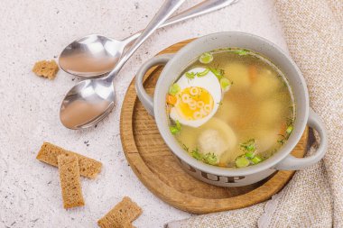 Haşlanmış yumurtalı köfte çorbası, ditalini makarna, sebze ve taze otlar. Sağlıklı tavuk çorbası, akşam yemeği için geleneksel sıcak yemek. Sert ışık, karanlık gölge, taş beton zemin, üst manzara