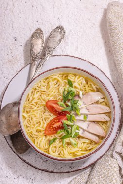 Baharatlı erişte ve et suyu. Sıcak yemek, çatal bıçak, sert ışık, karanlık gölge. Taş beton zemin, düz zemin, üst manzara