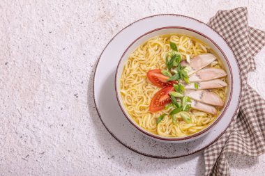 Baharatlı erişte ve et suyu. Sıcak yemek, çatal bıçak, sert ışık, karanlık gölge. Taş beton zemin, düz zemin, üst manzara