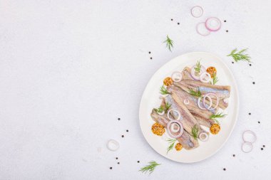 Dijon hardallı, dereotlu ve soğanlı ringa balığı. Terbiye edilmiş fileto balığı. Hafif taş üzerinde. Beton zemin, düz zemin, üst manzara.