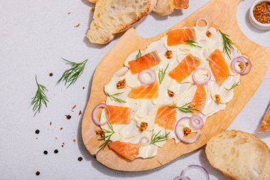 Somon, kırmızı soğan, hardal ve taze dereotlu tereyağı. Baget ekmekli ev yapımı aperatif, arkadaş partisi için sağlıklı vejetaryen konsepti. Hafif taş arkaplan, üst görünüm