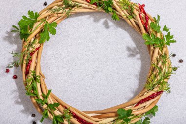 Taze yeşillik, acı biber ve biberli çelenk. Yuvarlak çerçeve, metin yeri, modaya uygun sert ışık, karanlık gölge, aydınlık taş beton zemin, düz zemin, üst manzara