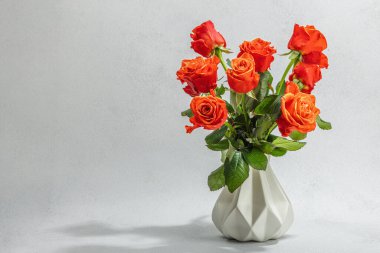 Vazonun üzerinde bir buket taze parlak gül. Romantik hediye konsepti, tebrik kartı. Sevgililer Günü, Kadınlar ya da Anneler Günü. Düğün, yıldönümü, doğum günü, düz zemin, taş beton zemin, kopyalama alanı