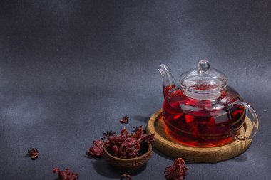 Hibiscus sıcak çay ve hurma. Koyu beton zeminde iftar ya da Suhoor yemeği için geleneksel Ramazan Kareem konsepti. Arap tatlısı, sert ışık, karanlık gölge, kopyalama alanı.