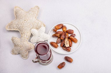 Hibiscus sıcak çay ve hurma. Hafif beton zeminde iftar ya da Suhoor yemeği için geleneksel Ramazan Kareem konsepti. Arap tatlısı, sert ışık, karanlık gölge, kopyalama alanı.