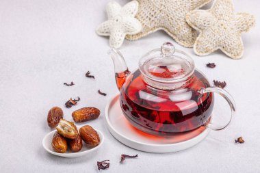 Hibiscus sıcak çay ve hurma. Hafif beton zeminde iftar ya da Suhoor yemeği için geleneksel Ramazan Kareem konsepti. Arap tatlısı, sert ışık, karanlık gölge, kopyalama alanı.