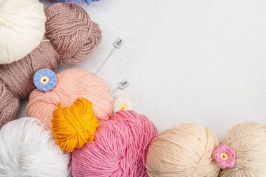 Örgü ve özel el işi aletleri için renkli bir demet iplik. El yapımı, hobi, tığ işi konsepti. Işık taşı, beton zemin, üst görünüm...