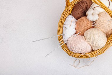 Sepette örgü örmek için bir demet pastel iplik. El yapımı, hobi, tığ işi konsepti. Işık taşı arkaplan, üst görünüm üzerine dekorlar ve özel sanatlar araçları