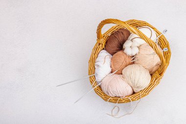 Sepette örgü örmek için bir demet pastel iplik. El yapımı, hobi, tığ işi konsepti. Işık taşı arkaplan, üst görünüm üzerine dekorlar ve özel sanatlar araçları