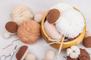 Örgü örmek için bir demet iplik. Tığ işi mantar, el yapımı, hobi konsepti. Işık taşı arkaplan, üst görünüm üzerine dekorlar ve özel sanatlar araçları