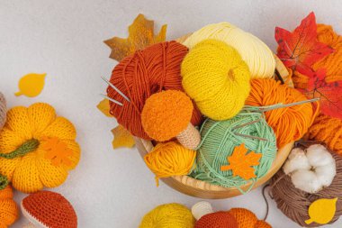 Örgü örmek için bir demet iplik. Tığ işi mantarlar, balkabakları, el yapımı, sonbahar hobisi. Işık taşı arkaplan, üst görünüm üzerine dekorlar ve özel sanatlar araçları