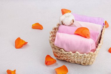 Eko dostu bahar tuvaleti temizliği, makine yıkama kapsülleri. Pastel renkli bebek tişörtleri, satış konsepti. Giysilerin dikey depolanması. Hafif taş arkaplan, boşluğu kopyala