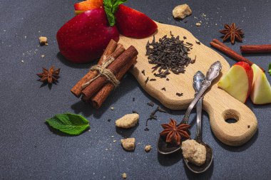 Tazeleyici yaz içeceği. Kuru çay yaprakları, taze meyve ve bitkiler. Çay hazırlamak için gerekli malzemeler, koyu ışık, koyu gölge. Koyu taş zemin, düz zemin, kopyalama alanı