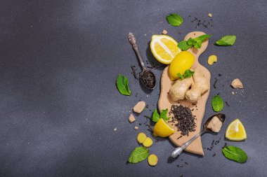 Tazeleyici yaz içeceği. Kuru çay yaprakları, taze meyve ve bitkiler. Çay hazırlamak için gerekli malzemeler, koyu ışık, koyu gölge. Koyu taş zemin, düz zemin, üst manzara