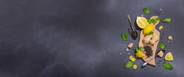 Tazeleyici yaz içeceği. Kuru çay yaprakları, taze meyve ve bitkiler. Çay hazırlamak için gerekli malzemeler, koyu ışık, koyu gölge. Koyu taş zemin, düz zemin, pankart biçimi