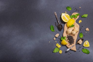 Tazeleyici yaz içeceği. Kuru çay yaprakları, taze meyve ve bitkiler. Çay hazırlamak için gerekli malzemeler, koyu ışık, koyu gölge. Koyu taş zemin, düz zemin, üst manzara