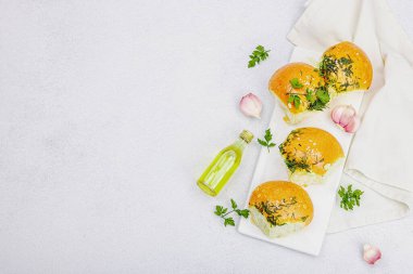 Aromatik sarımsaklı çörekler. Taze pişmiş yiyecekler, geleneksel glütensiz çorba atıştırmalıkları. Maydanoz, baharat, zeytinyağı. Hafif taş arkaplan, üst görünüm