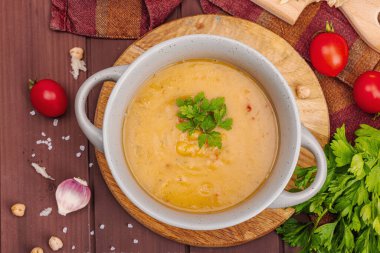 Kokulu sarımsaklı çörekle nohut-domates kremalı çorba. Rahatlatıcı yemekler, nostaljik ruh hali konsepti, sağlıklı vejetaryen yemeği. Ahşap zemin, düz yatış, üst manzara