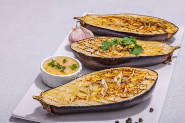 Zeytinyağlı ızgara patlıcan, sarımsak ve yeşillik. Piknik ya da barbekü için geleneksel yiyecekler, vegan sağlıklı yiyecekler. Modern sert ışık, karanlık gölge, taş beton zemin, kopyalama alanı