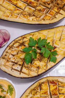 Zeytinyağlı ızgara patlıcan, sarımsak ve yeşillik. Piknik ya da barbekü için geleneksel yiyecekler, vegan sağlıklı yiyecekler. Modern sert ışık, karanlık gölge, taş beton zemin, üst görünüm