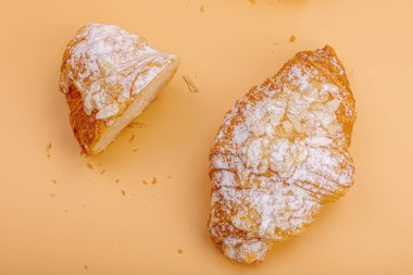 Günaydın konsepti. Krema dolgulu taze kruvasan ve badem gevreği. Tatlı tatlı, dekonstrüksiyon, seçici odaklanma, düz yatış, üst görünüm