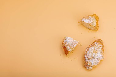 Günaydın konsepti. Krema dolgulu taze kruvasan ve badem gevreği. Tatlı tatlı, dekonstrüksiyon, seçici odaklanma, düz yatış, üst görünüm