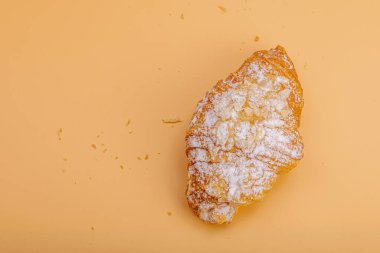 Günaydın konsepti. Krema dolgulu taze kruvasan ve badem gevreği. Tatlı tatlı, dekonstrüksiyon, seçici odaklanma, düz yatış, üst görünüm
