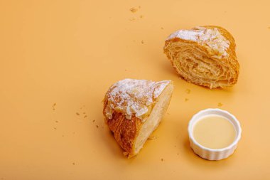 Günaydın konsepti. Krema dolgulu taze kruvasan ve badem gevreği. Tatlı tatlı, dekonstrüksiyon, seçici odaklanma, düz yatış, kopyalama alanı