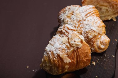 Günaydın konsepti. Krema dolgulu taze kruvasan ve badem gevreği. Tatlı tatlı, dekonstrüksiyon, seçici odaklanma, düz yatış, kopyalama alanı