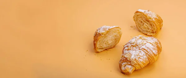 Good morning concept. Fresh croissants with cream filling and almond flakes. Sweet dessert, deconstruction, selective focus, flat lay, banner format