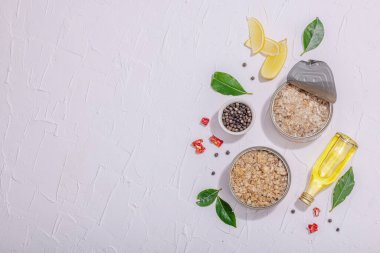 Baharat ve bitkilerle yağlı konserve balık ton balığı. Vejetaryen yaşam tarzı için sağlıklı malzeme. Deniz ürünleri, omega, düz yatak. Sert ışık, koyu gölge, beyaz alçı arka plan, üst görünüm