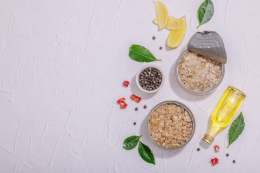 Baharat ve bitkilerle yağlı konserve balık ton balığı. Vejetaryen yaşam tarzı için sağlıklı malzeme. Deniz ürünleri, omega, düz yatak. Sert ışık, koyu gölge, beyaz alçı arka plan, üst görünüm