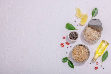Baharat ve bitkilerle yağlı konserve balık ton balığı. Vejetaryen yaşam tarzı için sağlıklı malzeme. Deniz ürünleri, omega, düz yatak. Sert ışık, koyu gölge, beyaz alçı arka plan, üst görünüm